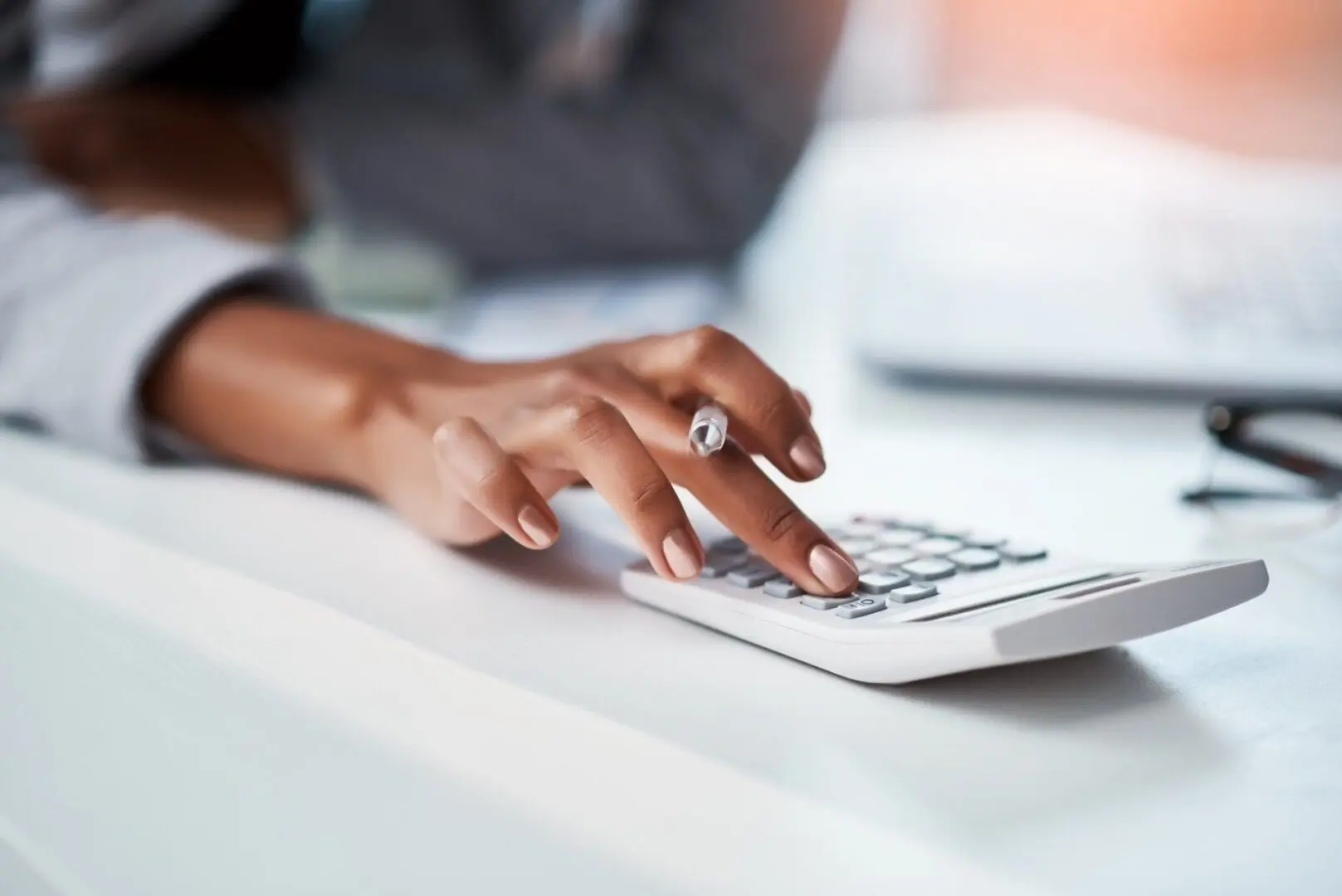 Woman's hand typing on calculator